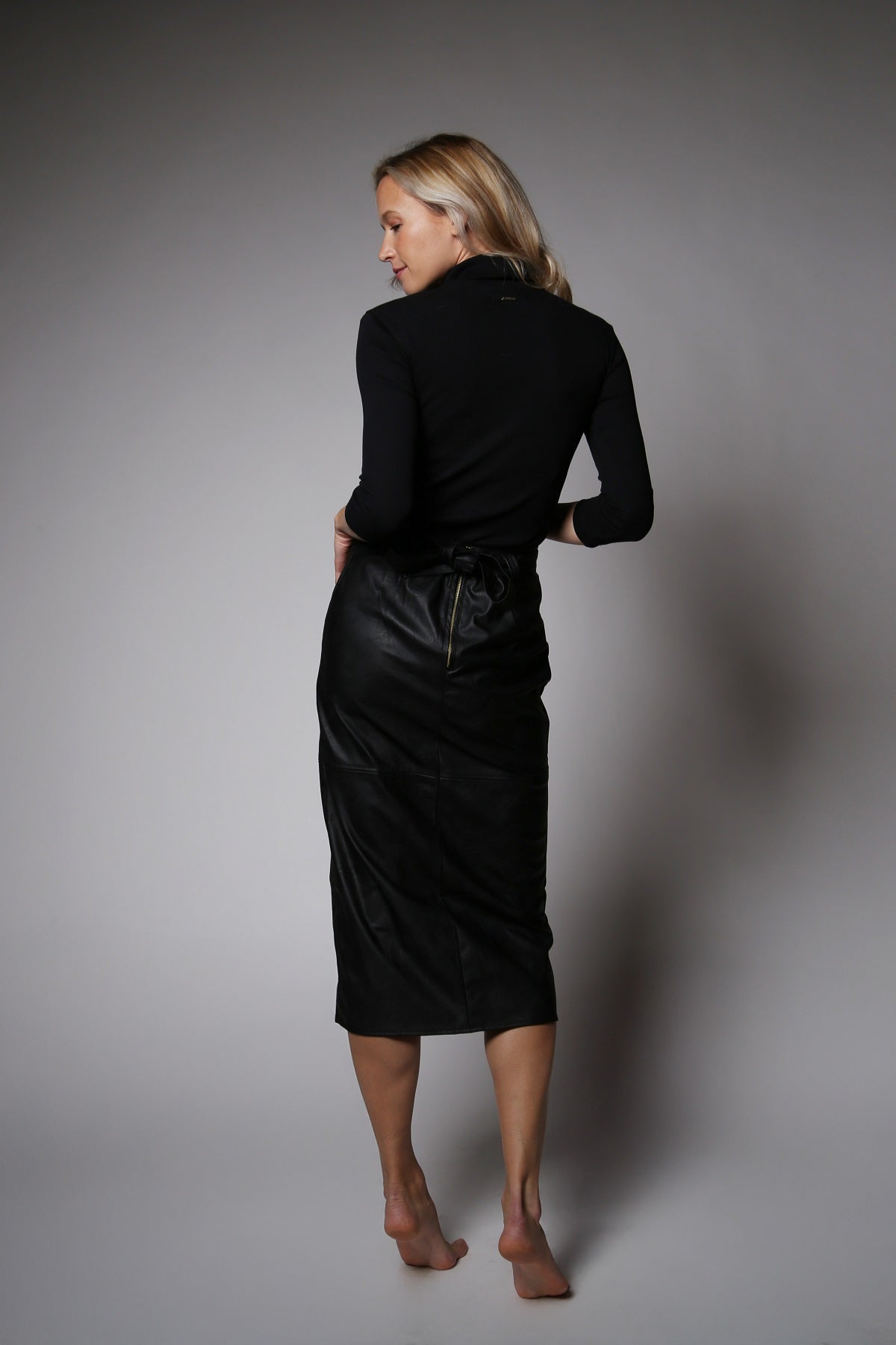 NOVINKA - Midi sukně z eko kůže s páskem a rozparkem – černá